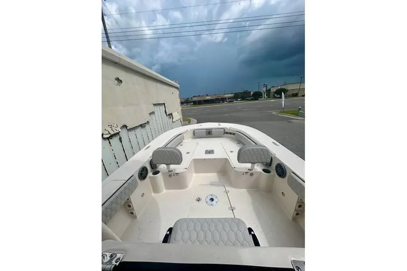 Slide: The Image of 2026 Carolina Skiff 24 Ultra Elite boat interior with seating and storage, under cloudy sky. - 5