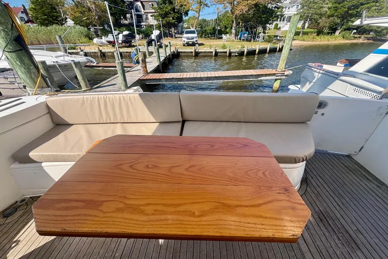 Slide: The Image of Luxurious 2004 Viking Princess 61 Fly Bridge yacht with elegant outdoor seating and wooden table. - 18