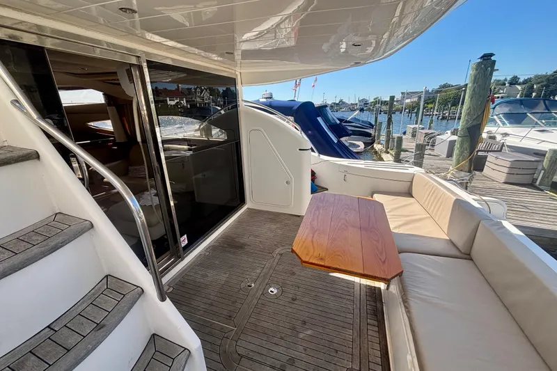 Slide: The Image of 2004 Viking Princess 61 Fly Bridge yacht with outdoor seating and dock view. - 19