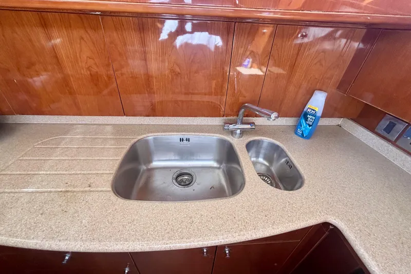 Slide: The Image of Kitchen sink area in 2004 Viking Princess 61 Fly Bridge yacht with wooden cabinetry. - 31