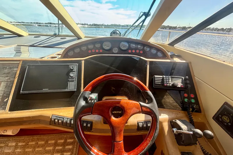 Slide: The Image of Helm of 2004 Viking Princess 61 Fly Bridge yacht with steering wheel and navigation controls. - 37
