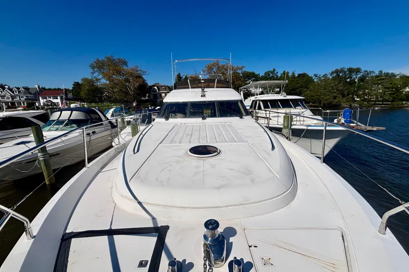 Slide: The Image of 2004 Viking Princess 61 Fly Bridge yacht docked at marina under clear blue sky. - 6
