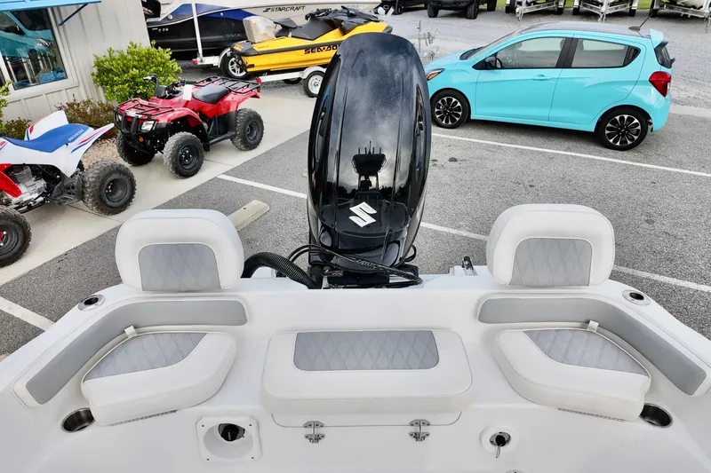 Slide: The Image of Boat interior with Suzuki engine, surrounded by ATVs and a blue car in a parking lot. - 10