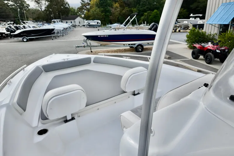 Slide: The Image of 2026 ALK2 22CRX boat interior with seating, parked in a marina with other boats. - 7