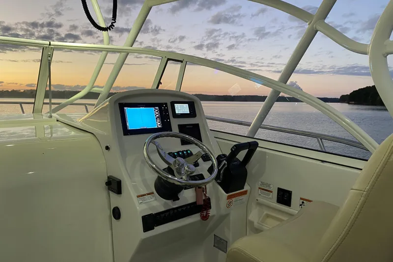 Slide: The Image of 2020 Sailfish 270 WAC boat helm with sunset view over calm waters. - 12