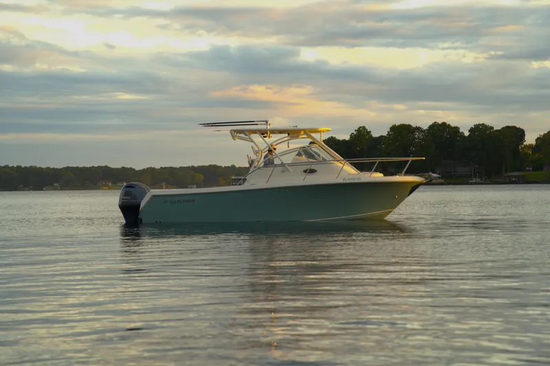 Slide: The Image of 2020 Sailfish 270 WAC boat on calm water at sunset. - 2