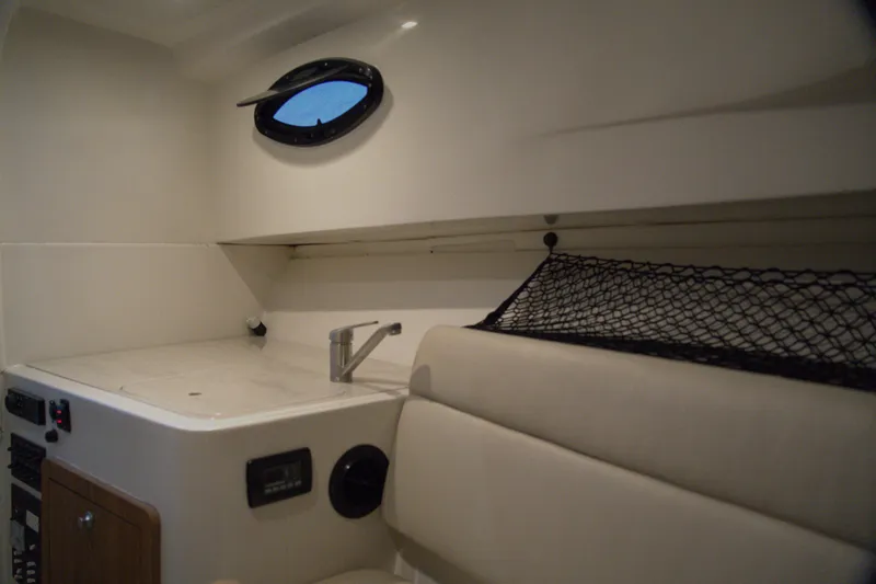 Slide: The Image of Interior of 2020 Sailfish 270 WAC boat with sink, seating, and storage net. - 25
