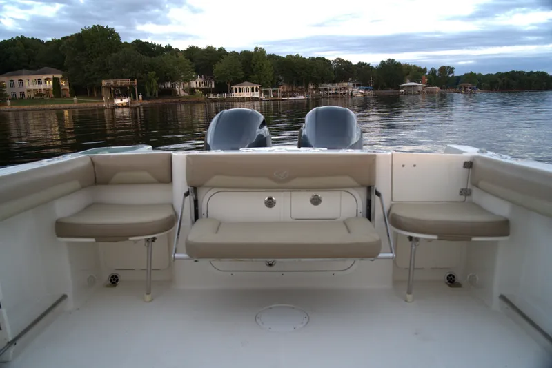 Slide: The Image of 2020 Sailfish 270 WAC boat interior with seating, overlooking a serene lake view. - 7
