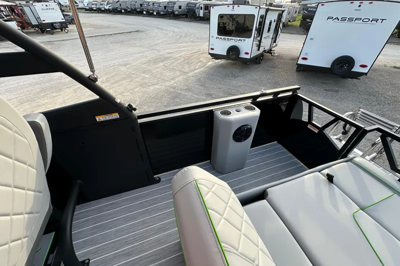 Slide: The Image of 2024 Veranda VX 25 DCVL boat interior with seating and cup holders, parked near RVs. - 19