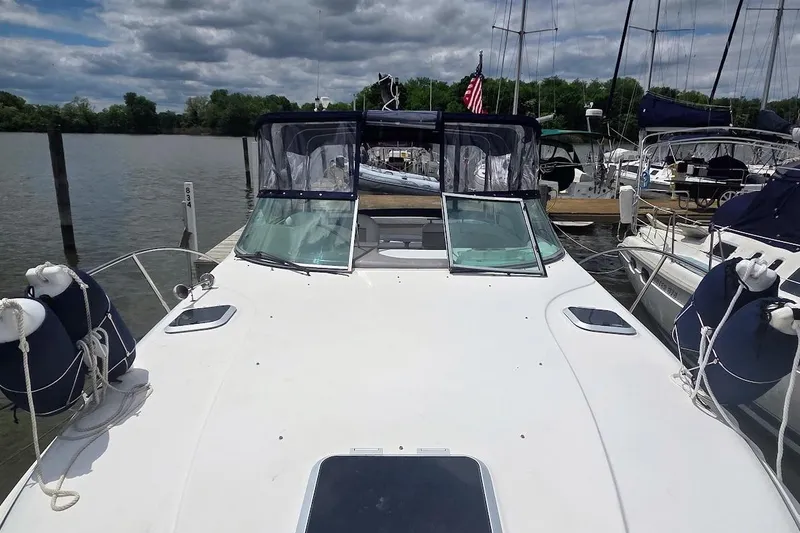 Slide: The Image of 2007 Rinker 320 Express Cruiser docked, featuring a spacious deck and clear skies. - 10