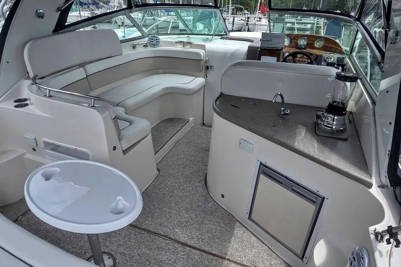 Slide: The Image of 2007 Rinker 320 Express Cruiser interior with seating, kitchenette, and helm. - 12