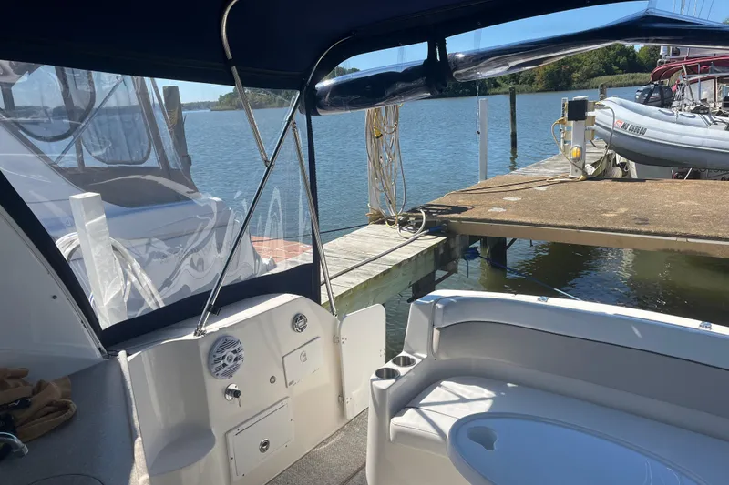 Slide: The Image of 2007 Rinker 320 Express Cruiser docked by a serene waterfront. - 16