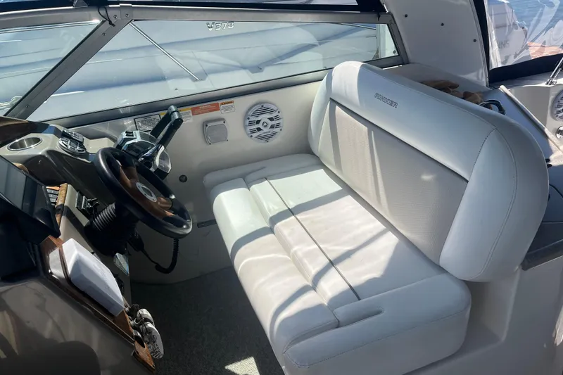 Slide: The Image of 2007 Rinker 320 Express Cruiser cockpit with white seating and steering wheel. - 20