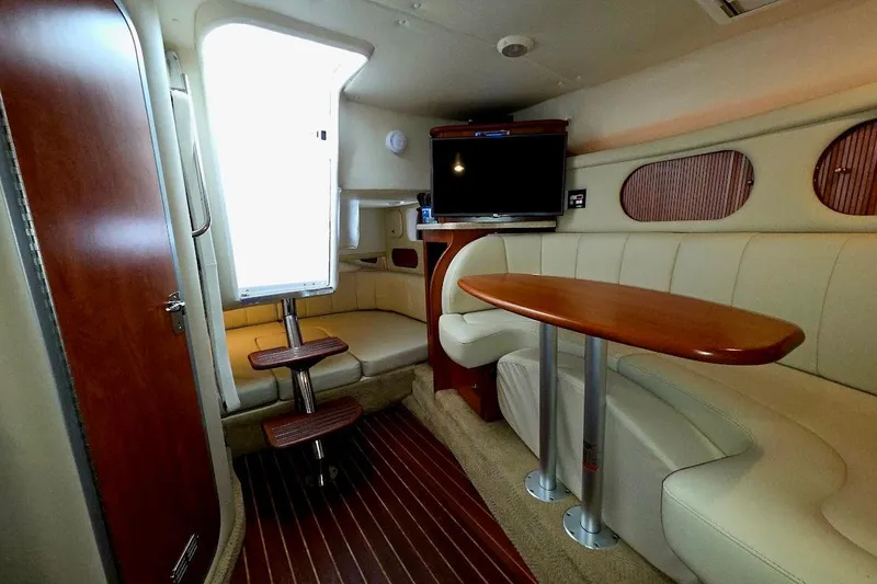 Slide: The Image of 2007 Rinker 320 Express Cruiser interior with plush seating and wooden table. - 22