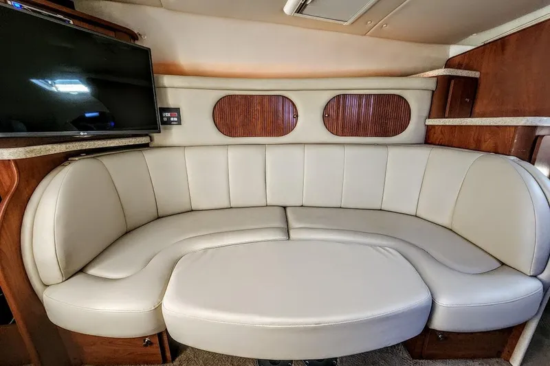 Slide: The Image of 2007 Rinker 320 Express Cruiser interior with curved leather seating and mounted TV. - 23