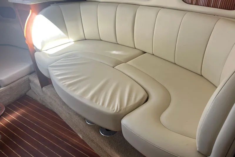 Slide: The Image of 2007 Rinker 320 Express Cruiser interior with cream leather seating and wooden flooring. - 24