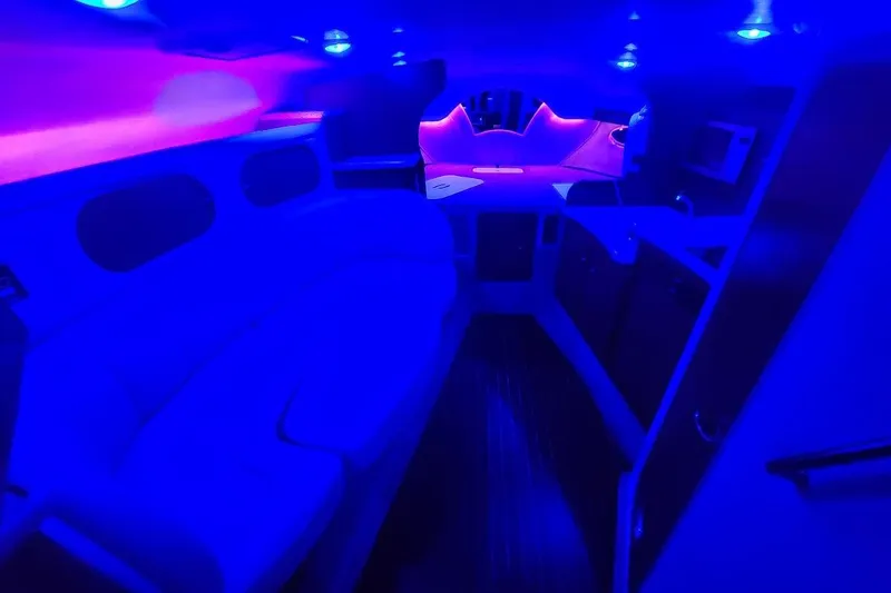 Slide: The Image of 2007 Rinker 320 Express Cruiser interior with vibrant blue and pink lighting. - 27