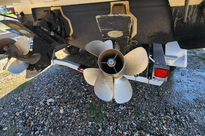 Slide: The Image of 2007 Rinker 320 Express Cruiser propellers and stern on a gravel surface. - 29