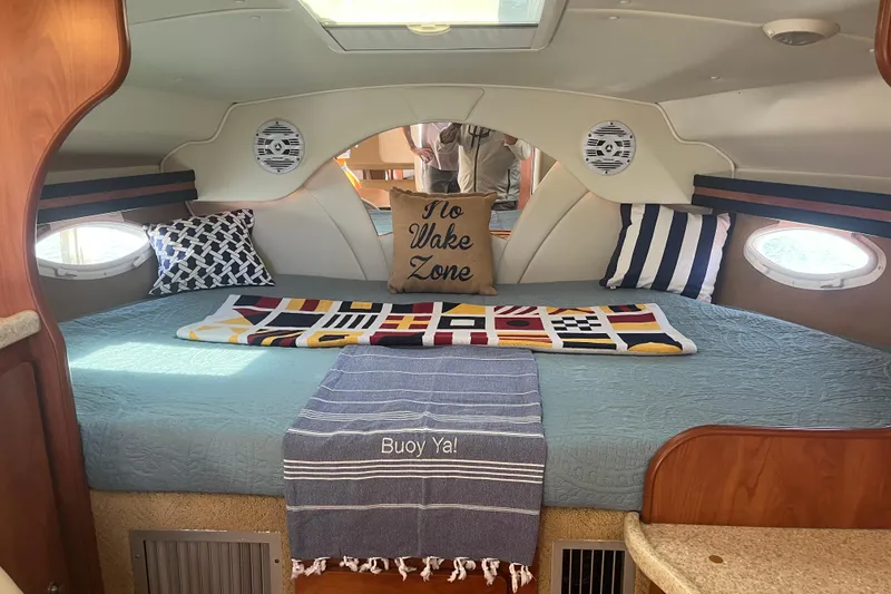 Slide: The Image of 2007 Rinker 320 Express Cruiser cabin with nautical decor and cozy bedding. - 4