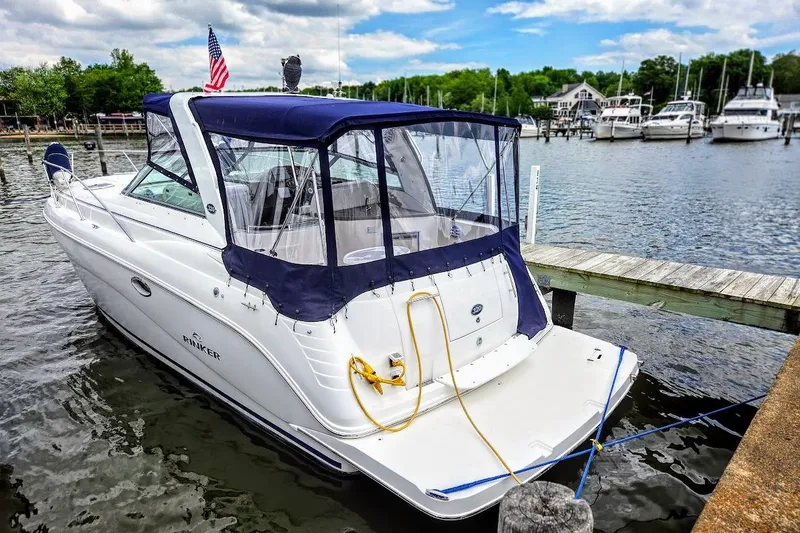 Slide: The Image of 2007 Rinker 320 Express Cruiser docked at a marina with scenic waterfront views. - 6