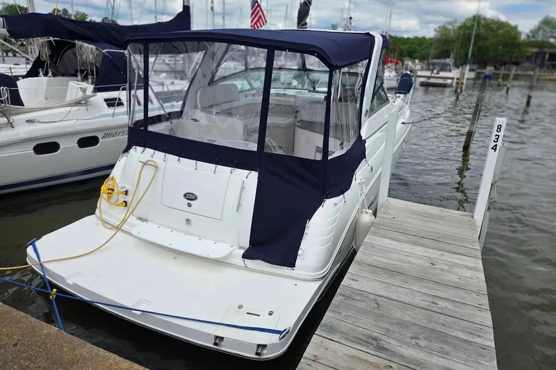 Slide: The Image of 2007 Rinker 320 Express Cruiser docked at a marina with blue canopy. - 8