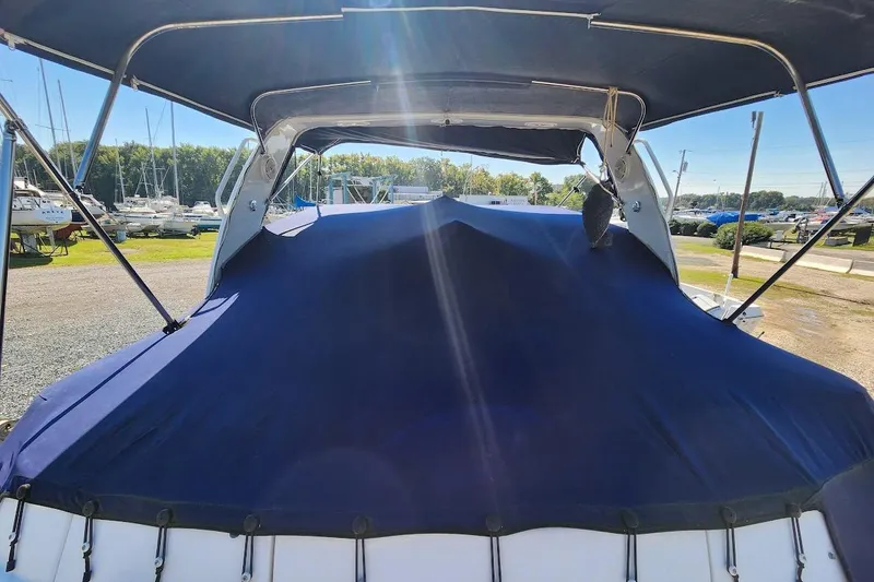 Slide: The Image of 2007 Rinker 320 Express Cruiser with blue cover in a marina setting. - 9