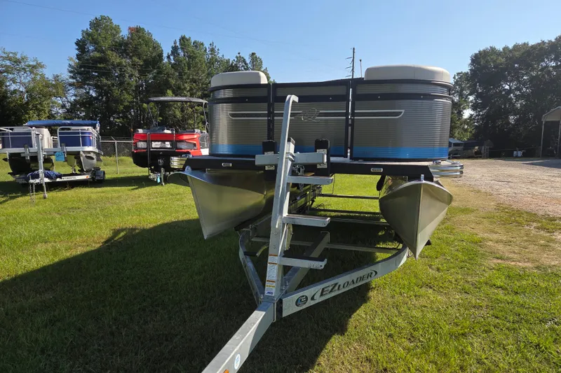 Slide: The Image of 2023 Qwest RLS 820 pontoon boat on trailer, parked on grassy area. - 2