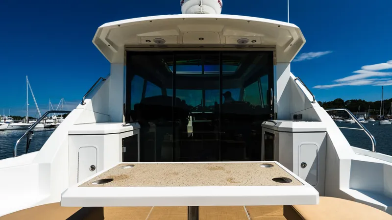 Slide: The Image of 2013 Cruisers Yachts 48 Cantius, rear view with table, docked in marina. - 15