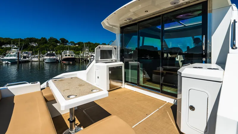 Slide: The Image of 2013 Cruisers Yachts 48 Cantius deck with seating, table, and marina view. - 17