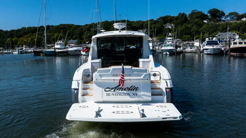 Slide: The Image of 2013 Cruisers Yachts 48 Cantius in marina, rear view with American flag. - 9