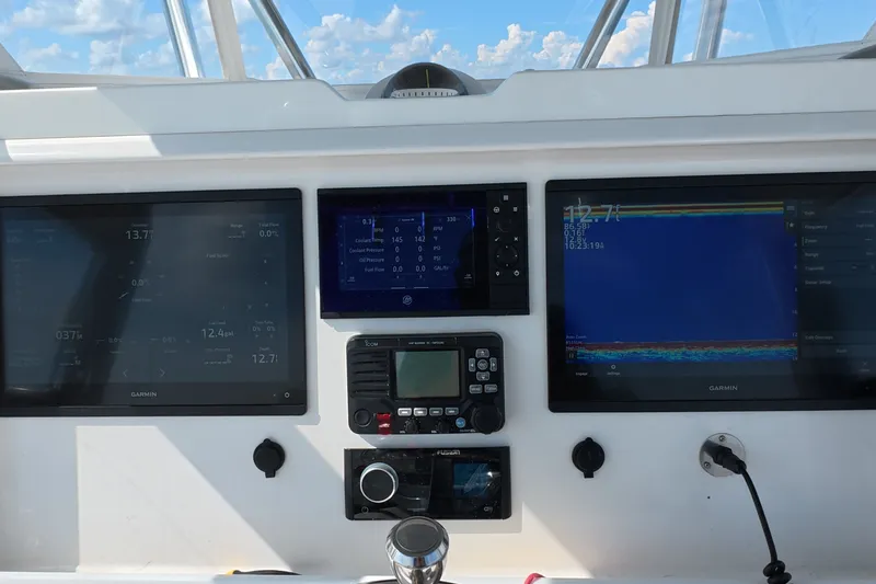 Slide: The Image of Dashboard of 2023 Invincible 33 Catamaran with Garmin navigation displays. - 2