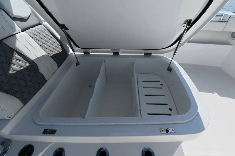 Slide: The Image of Open storage compartment on 2023 Invincible 33 Catamaran with cushioned seating. - 8