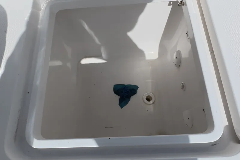 Slide: The Image of Open storage compartment on 2023 Invincible 33 Catamaran with a blue cloth inside. - 26