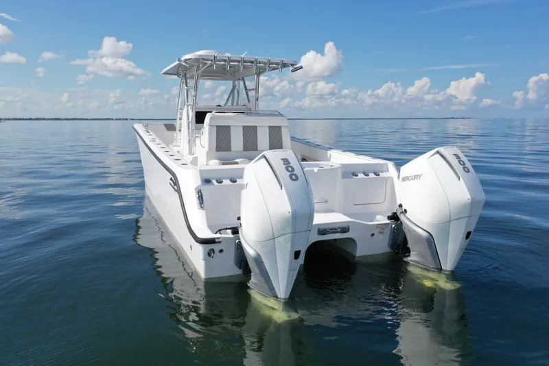 Slide: The Image of 2023 Invincible 33 Catamaran with twin Mercury engines on calm ocean waters. - 0
