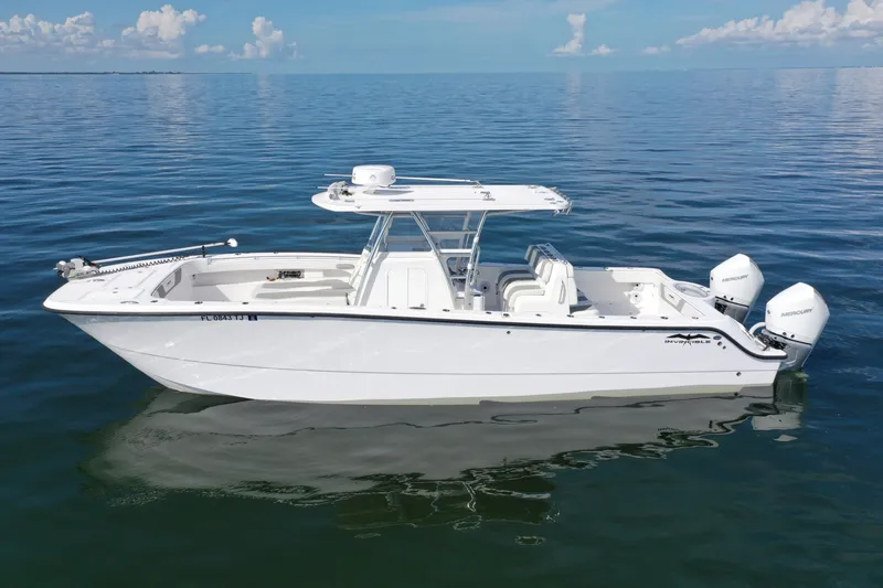 Slide: The Image of 2023 Invincible 33 Catamaran on calm ocean waters, showcasing sleek design and twin engines. - 11