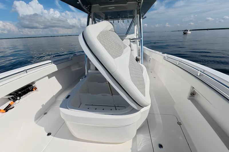 Slide: The Image of 2023 Invincible 33 Catamaran with open storage compartment on calm ocean waters. - 9