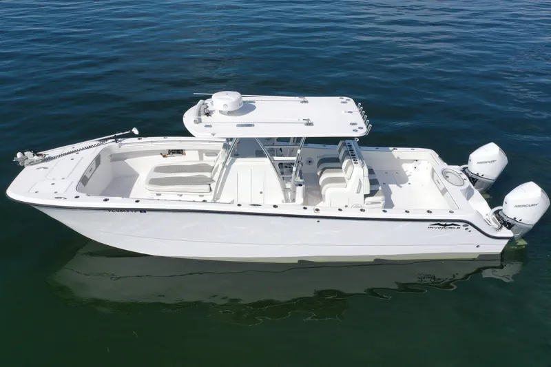 Slide: The Image of 2023 Invincible 33 Catamaran on calm water, featuring dual Mercury engines. - 13