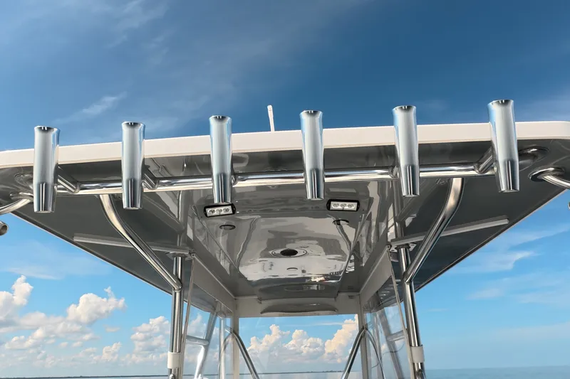 Slide: The Image of 2023 Invincible 33 Catamaran T-top with rod holders against a clear blue sky. - 34