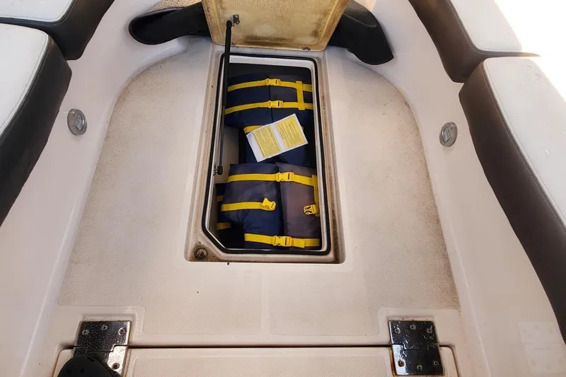 Slide: The Image of 2010 Regal 2700 ES Bowrider storage compartment with life jackets inside. - 12
