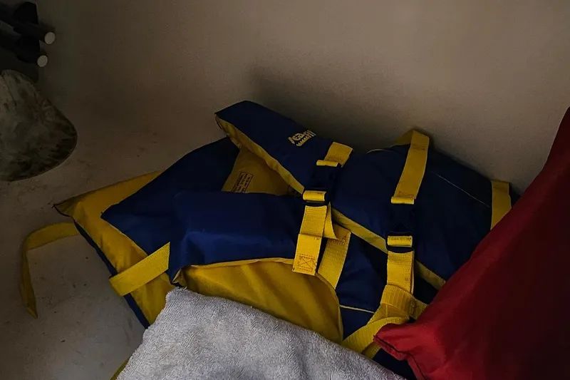 Slide: The Image of Blue and yellow life jackets stored on a 2010 Regal 2700 ES Bowrider boat. - 24