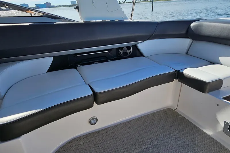 Slide: The Image of 2010 Regal 2700 ES Bowrider interior seating with black and white upholstery, near water. - 35
