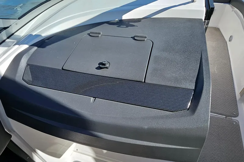 Slide: The Image of 2010 Regal 2700 ES Bowrider dashboard with storage compartment, black and white design. - 37