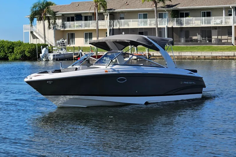 Slide: The Image of 2010 Regal 2700 ES Bowrider boat cruising on a sunny waterfront. - 54