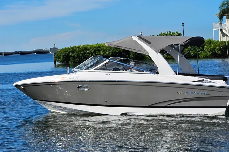 Slide: The Image of 2010 Regal 2700 ES Bowrider cruising on a sunny day, featuring sleek design and canopy. - 57