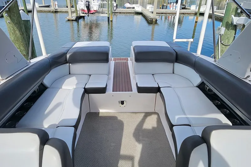 Slide: The Image of 2010 Regal 2700 ES Bowrider interior with plush seating at a marina. - 7