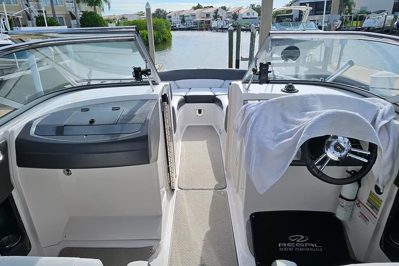 Slide: The Image of 2010 Regal 2700 ES Bowrider interior with steering wheel, dashboard, and waterfront view. - 9