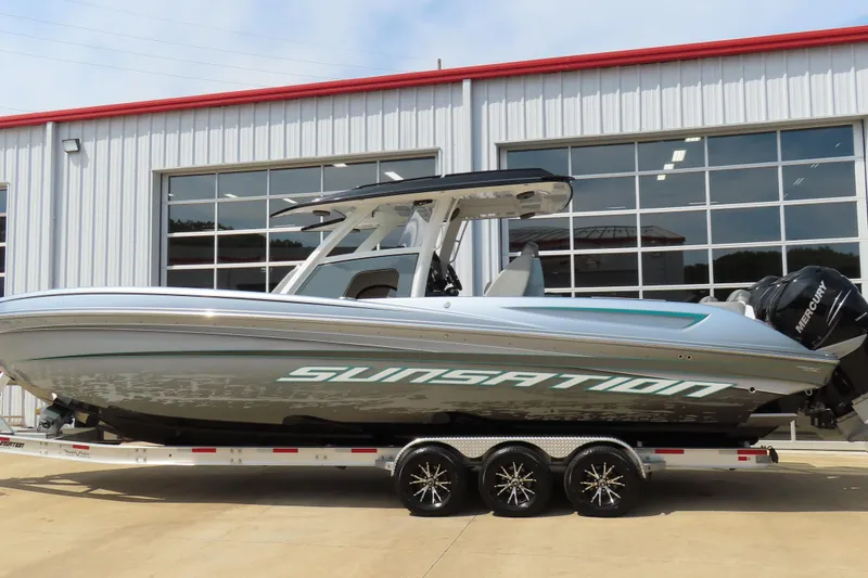 Slide: The Image of 2020 Sunsation 34 CCX boat on trailer, parked outside a garage. - 11