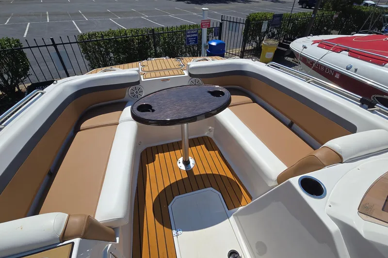 Slide: The Image of 2021 Starcraft SVX 191 OB boat interior with seating and table, parked outdoors. - 42