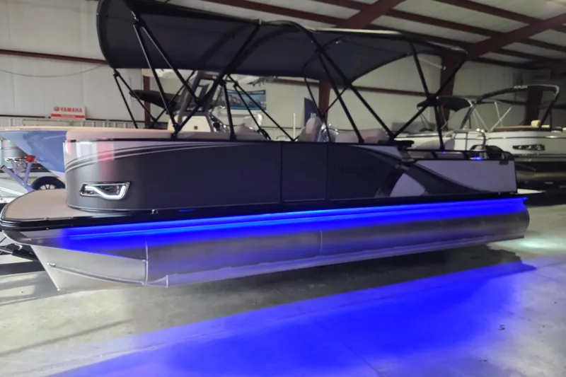 Slide: The Image of 2026 Avalon Platinum LSZ 2385 Entertainer pontoon boat with blue LED lights in a showroom. - 12
