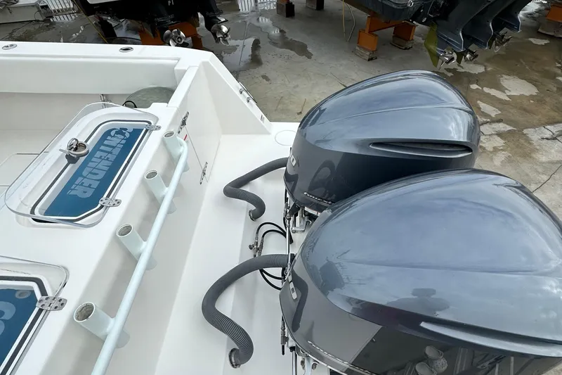 Slide: The Image of 2019 Contender 32 ST boat cockpit with dual screens, steering wheel, and ocean view. - 14